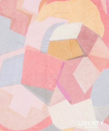 A close-up of Liberty Fabrics' abstract geometric patterned fabric, featuring overlapping shapes in soft pink, peach, yellow, light blue, and cream.