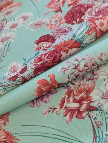 Floral fabric with pink and red flowers on a pastel background