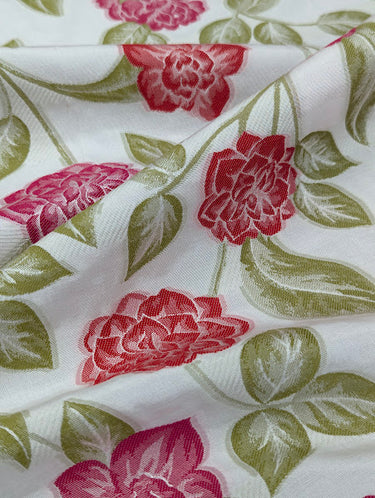 Floral fabric with red flowers and green leaves on a white background