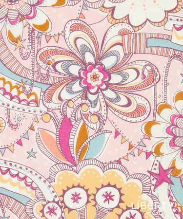A close-up of a Liberty Fabrique fabric print featuring a whimsical, hand-drawn floral and paisley pattern in pink, orange, yellow, and light blue on a pale pink background.