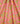 Pink fabric with a dense floral and paisley pattern in yellow, teal, and orange, shown with soft folds.