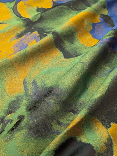 Close-up of a textured fabric with green, yellow, and blue colors.