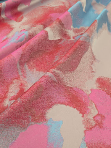 Close-up of fabric with pink, blue, and beige abstract pattern