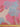 Fabric with abstract pattern in pink, red and blue shown with a ruler at the bottom for scale.