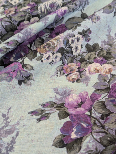 Floral fabric with purple and grey flowers on a light blue background