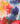 Abstract watercolor fabric pattern with blended splashes of red, orange, yellow, purple, blue, teal, and white.