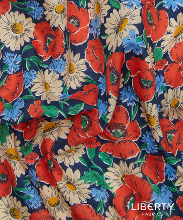 A close-up of a Liberty Fabrics floral fabric print featuring red poppies, cream daisies, and blue flowers on a dark navy background.