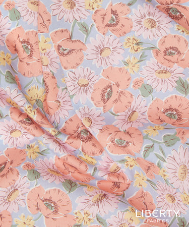 A close-up of Liberty Fabrics floral print fabric featuring large peach poppies, white daisies, and small yellow flowers on a light blue background.
