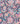 A close-up of a colorful paisley and floral patterned fabric with a dark navy background and bright multicolor motifs including pink, orange, teal, yellow, and white. A small 'Liberty Fabrics' logo watermark is visible in the bottom right corner.