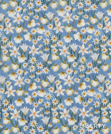 Floral pattern with white flowers on a blue background, featuring the Liberty Fabrics logo.