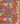 A close-up of a floral fabric pattern on a red background, featuring blue, yellow, and orange flowers with green leaves.