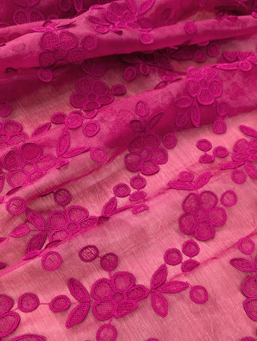 Close-up of pink organza fabric with 3D floral embroidery