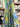 Tropical floral fabric with blue, green, and yellow colors in a store setting.