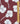 A close-up of a fabric pattern featuring white pansy flowers on a deep burgundy background, with a gold metal ruler on the right side for scale and a 'Liberty Fabrics' logo in the bottom right corner.
