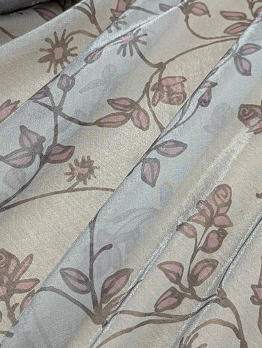 Close-up view of shimmer printed chiffon fabric with floral patterns.