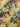Close up of floral patterned fabric with colourful flowers and leaves on a yellow background