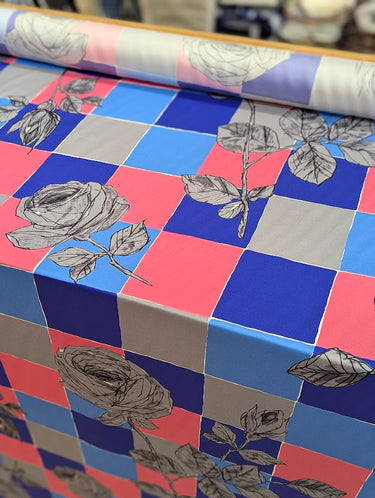 Roll of floral-patterned fabric with a checkered background