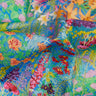 A close-up of colorful Liberty Fabrics featuring a dense botanical and floral pattern with blue, green, pink, red, yellow, and orange tones.