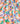 A close-up of draped fabric with a colorful abstract geometric pattern featuring orange, blue, green, yellow, and pink shapes on a white background. 