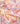A close-up of draped Liberty Fabrics featuring a pastel geometric pattern with pink, peach, yellow, and light gray shapes.