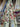 Floral fabric with red, purple, and blue flowers on a cream background draped within a shop setting.