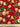 Close-up of a printed wool fabric with yellow flowers on a red background, shown with a ruler at the bottom for scale.