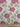 Floral fabric pattern with red flowers and green leaves on a white background, shown with a ruler for scale.