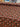 Roll of floral-patterned paper with red and pink flowers on a brown background.