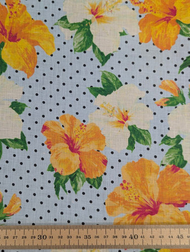 Floral fabric with yellow and white flowers on a polka dot background, ruler at the bottom for scale.
