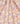 A close-up of draped fabric with a dense floral and paisley print in soft pink, yellow, white, teal, and brown. The fabric fills the entire frame, with a 'LIBERTY' watermark visible in the bottom right corner.