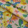 Colorful floral fabric with yellow, pink, and green flowers on a light pink background.