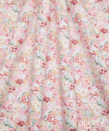 A close-up of a lightweight fabric with a soft, draped texture, featuring a delicate floral pattern in pink, red, yellow, and green on a white background.