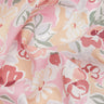 A close-up of draped fabric with a soft floral print in pastel pink, peach, white, coral, and muted green. The Liberty Fabrics logo is visible in the bottom right corner.