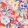 A close-up of a Liberty brand fabric pattern featuring a colorful floral design on a coral red background with white, blue, yellow, and green elements.