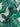 Close-up of a fine printed cotton lawn fabric with green banana leaves on a white background