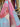 Close-up of textured fabric with pink, red and blue draped within a store setting