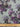 Floral fabric pattern with purple and grey flowers on a light blue background, measured with a ruler at the bottom.