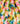 A close-up of draped fabric with a watercolor-style multicolor print featuring pink, yellow, blue, green, orange, and white tones. The Liberty Fabrics logo is visible in the bottom right corner.