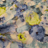 A linen fabric featuring a floral pattern with shades of blue, yellow, and grey, giving an impressionist garden look.
