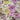 A close up of a linen fabric featuring a floral print with soft colours like pink and yellow