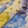 Close-up of floral fabric with blue, yellow, and purple flowers.