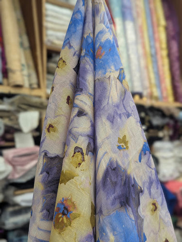 Floral fabric with blue and white flowers draped in a fabric store setting