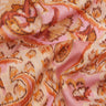 A close-up of draped Liberty Fabrics featuring a pink, orange, and beige ikat pattern.