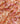 A close-up of draped Liberty Fabrics featuring a pink, orange, and beige ikat pattern.