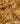 A close-up of draped Liberty Fabrics featuring a golden yellow and beige ikat pattern with brown accents.