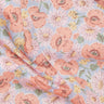 A close-up of Liberty Fabrics floral print fabric featuring large peach poppies, white daisies, and small yellow flowers on a light blue background.