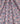 A close-up of draped fabric featuring a detailed, multicolored traditional pattern with pink, orange, teal, and white motifs on a dark navy base. A white 'LIBERTY Fabrics' logo is visible in the bottom right corner.