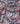 A close-up of a multicolor paisley fabric with intricate floral and ornamental patterns on a dark navy background. The fabric is draped to show its texture and pattern density.