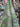 Fabric with nautical pattern featuring shells and ropes on a green background draped in a store setting