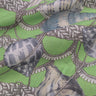 Close-up of fabric with nautical pattern featuring shells and ropes on a green background